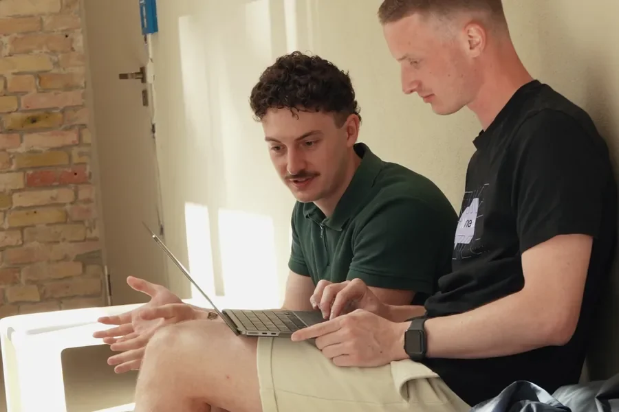 Two Web3 Factory team members working together on a laptop